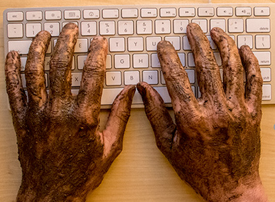 Hands dirty from working typing on keyboard 