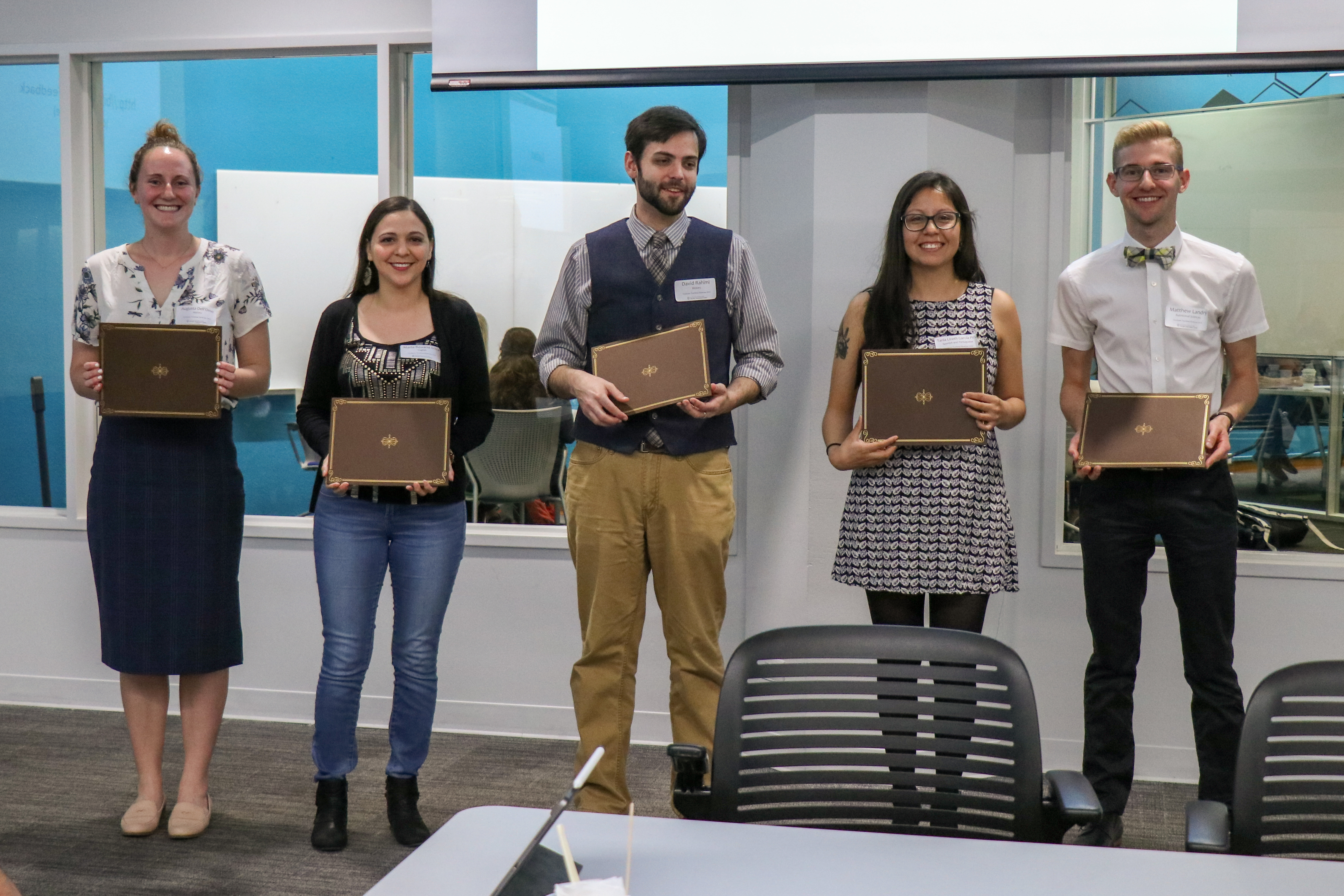 people holding certificates in a row