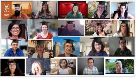 A virtual meeting screenshot displays 20 individuals wearing graduation caps, smiling towards the camera, with various backgrounds visible in their individual video frames.