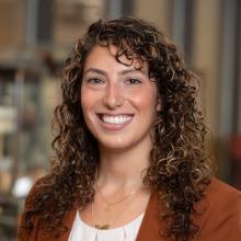 Tonia Guida Headshot Tonia Guida Headshot with curly hair and burgundy blouse