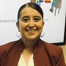 Patricia Candelaria Headshot Patricia Candelaria Headshot with brown hair tied back with a brown blazer