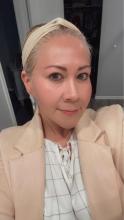 Cristina Santos Headshot Cristina Santos Headshot with a blonde hair tied back, a head band and pink cream blazer..