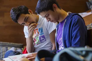 a pair of students looking a book