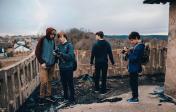 group of students working on a project outside balcony overlooking countryside.