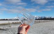 a hand holds out a square piece of ice