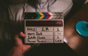 A directors clapboard in front of people - getting ready to make a scene.