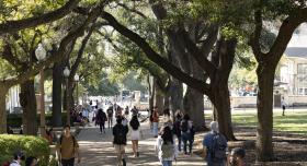Student walking in the shade on the UT Austin campus
