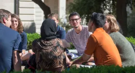 Students sitting on campus in a group