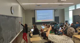 Student teaching and camera man filming behind her