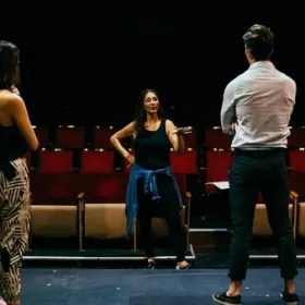 Director giving feedback to two actors in the foreground