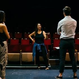 Director giving feedback to two actors in the foreground