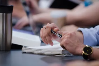 Image of a man holding a pen above paper