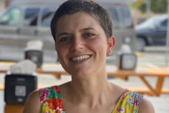 Short haired woman sitting at a table. Francesca Di Rienzo headshot
