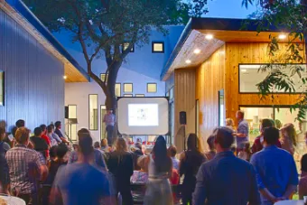 Folks gathered in the backyard in the evening