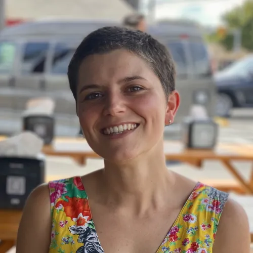 Francesca Di Rienzo headshot Short haired woman sitting at a table. Francesca Di Rienzo headshot