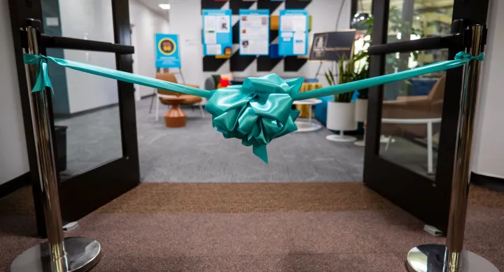 Turquoise box placed in front of two open doors leading into office suite.