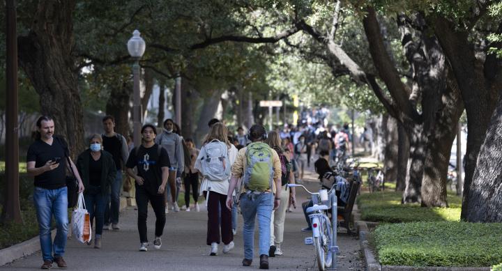 Students walking along 24th St. near Welch Hall between classes walking sunny day, between classes