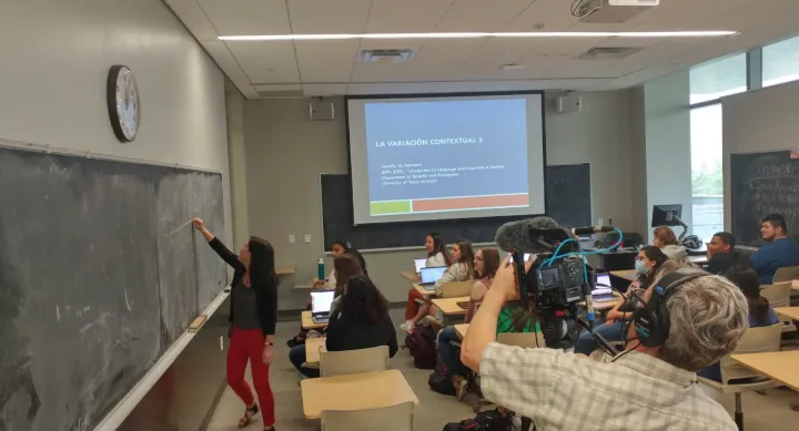 Student teaching and camera man filming behind her