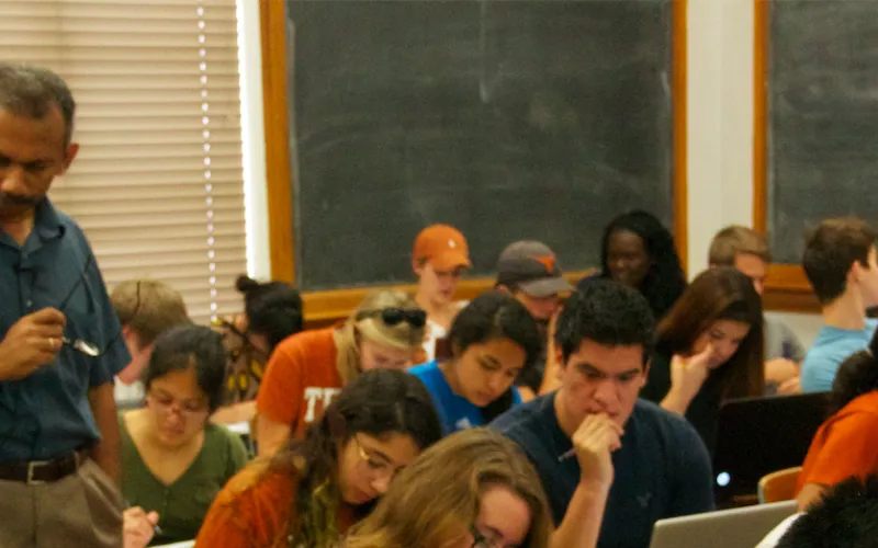 Professor in the midst of students engaged in learning activity during lecture