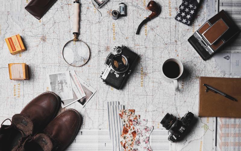 map on table with camera, shoes, magnifying glass, pipe, and other items spreadout over it... gearing up for an adventure
